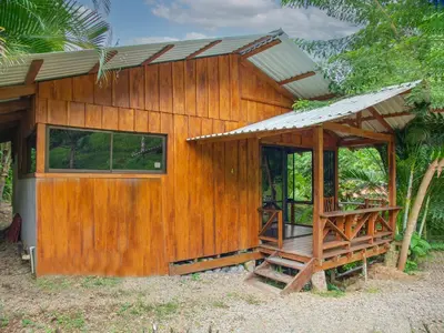 a small wooden house with a porch at Cabañas del Lago in Fortuna