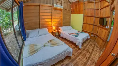 a bedroom with two beds in a room with a window at Cabañas del Lago in Fortuna