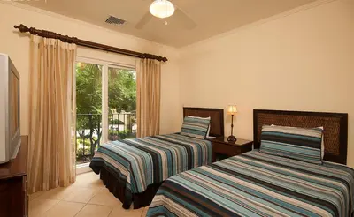 two beds in a room with a window at Ocean View Condo in Los Sueños in Herradura
