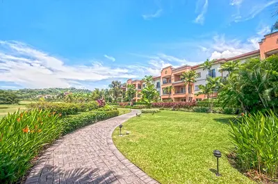 a brick walkway in a park next to a building at Ocean View Condo in Los Sueños in Herradura