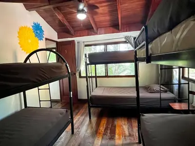 a room with two bunk beds and a window at Tamarindo Backpackers in Tamarindo