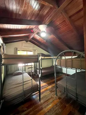 two bunk beds in a room with wooden ceilings at Tamarindo Backpackers in Tamarindo
