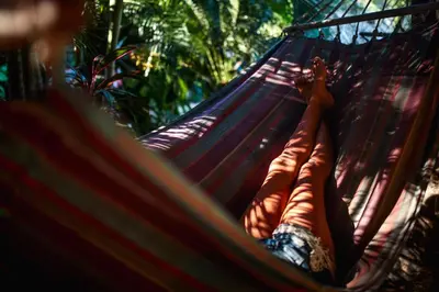 a person laying in a hammock at Tamarindo Backpackers in Tamarindo