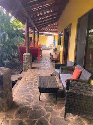 an outdoor patio with chairs and tables and a table at Tamarindo Backpackers in Tamarindo