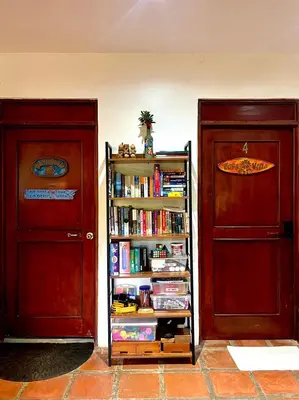 a book shelf filled with books next to two doors at Tamarindo Backpackers in Tamarindo