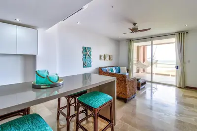 a kitchen and living room with a table and chairs at Breakwater Point 602 in Jacó