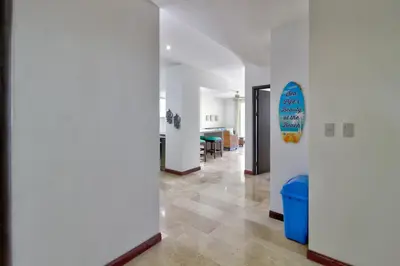 a hallway with white walls and a surfboard on a wall at Breakwater Point 602 in Jacó
