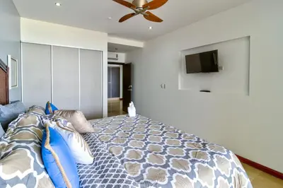 a bedroom with a bed and a flat screen tv at Breakwater Point 602 in Jacó