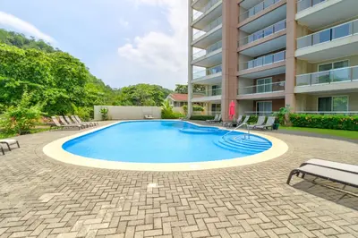 a swimming pool in front of a building at Breakwater Point 602 in Jacó