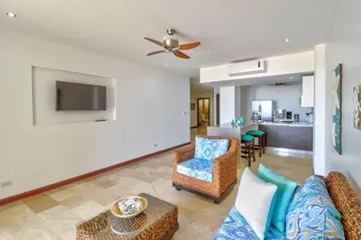 a living room with a couch and chairs and a kitchen at Breakwater Point 602 in Jacó