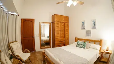a bedroom with a bed and a dresser and a mirror at Villas Welcome to Heaven in Carrillo