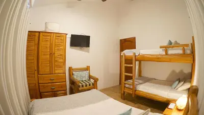 a bedroom with two bunk beds and a chair at Villas Welcome to Heaven in Carrillo
