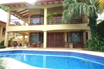 a house with a swimming pool in front of it at Villas Welcome to Heaven in Carrillo
