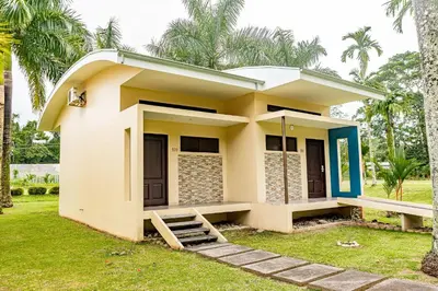 a small house with a green lawn in front of it at Hotel Los Rios in Guácimo