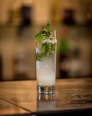 a drink on a table with a green garnishment at Hotel Los Rios in Guácimo