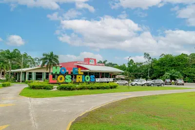 a building with a sign that says go hot dogs at Hotel Los Rios in Guácimo