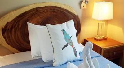 a bedroom with a bed with a bird on the pillows at Hotel La Gaviota Tropical in Playa Hermosa