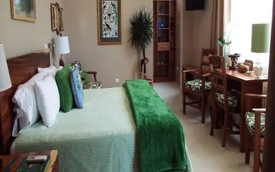 a bedroom with a bed with a green blanket on it at Hotel La Gaviota Tropical in Playa Hermosa