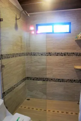 a shower with a glass door in a bathroom at Casa Donna Rosa B&B in Nuevo Arenal