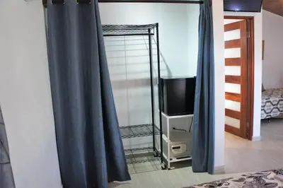 a bedroom with blue curtains and a television at Casa Donna Rosa B&B in Nuevo Arenal