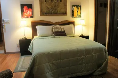 a bedroom with a large bed with two lamps at Casa Donna Rosa B&B in Nuevo Arenal