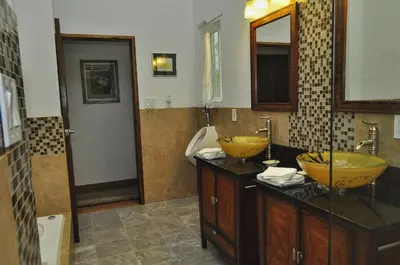 a bathroom with two yellow sinks and a tub at Casa Donna Rosa B&B in Nuevo Arenal