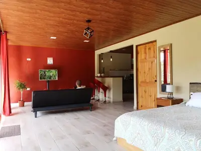 a person sitting on a bed in a bedroom at La Guayaba Monteverde in Monteverde Costa Rica