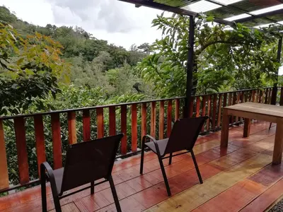 a deck with two chairs and a table with a view at La Guayaba Monteverde in Monteverde Costa Rica