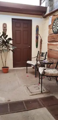 a pair of benches sitting in front of a door at Hostel Dodero in Liberia
