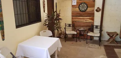 a room with a table and chairs and a dartboard at Hostel Dodero in Liberia