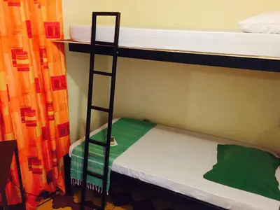 a bunk bed with a ladder in a room at Hostel Dodero in Liberia