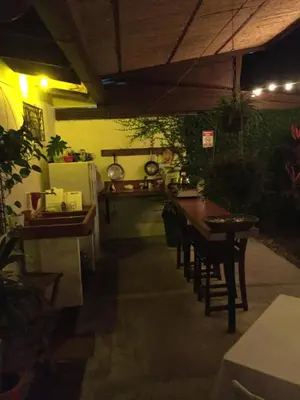 a patio with a table and chairs and a refrigerator at Hostel Dodero in Liberia
