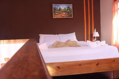 a bed with white sheets and towels on it at Quinta los volcanes in Turrialba