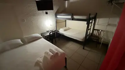 a small room with two bunk beds and a table at Hostel Pura Vida en Liberia in Liberia