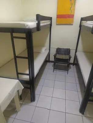 a room with two bunk beds and a stool at Hostel Pura Vida en Liberia in Liberia
