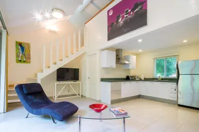 a living room with a blue chair and a table at The Breeze Hotel & Villas in Tamarindo
