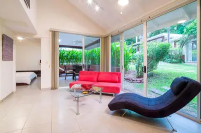 a living room with a red couch and a table at The Breeze Hotel & Villas in Tamarindo