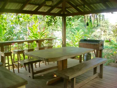 a wooden table and benches on a wooden deck at The Breeze Hotel & Villas in Tamarindo
