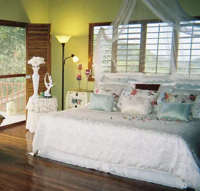 a bedroom with a large white bed and a window at Light of Dawn in Quepos