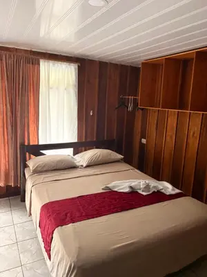 a bedroom with two beds and a window at Hospedaje Angeluz in Quesada