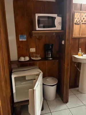 a small kitchen with a microwave and a sink at Hospedaje Angeluz in Quesada