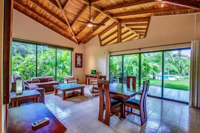 an open living room with a table and chairs at Hidden Palms in Nosara