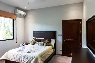 a bedroom with a bed with towels on it at Hidden Palms in Nosara