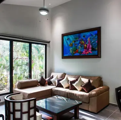 a living room with a couch and a painting on the wall at Hidden Palms in Nosara