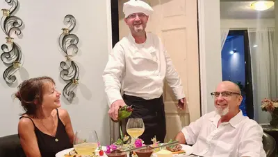 a man in a chef outfit standing next to a woman at El Encanto Condominiums in Jacó
