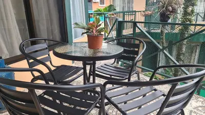 a table and chairs on a balcony with a potted plant at El Encanto Condominiums in Jacó