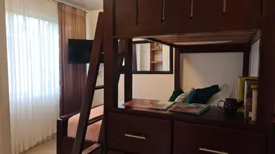 a bedroom with a bunk bed with a dresser and a mirror at El Encanto Condominiums in Jacó