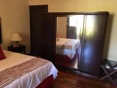 a bedroom with a bed and a dresser with a mirror at Hotel Hacienda El Rodeo in Rodeo