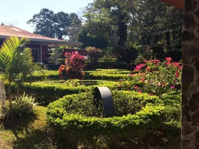 a garden with bushes and flowers in front of a house at Hotel Hacienda El Rodeo in Rodeo