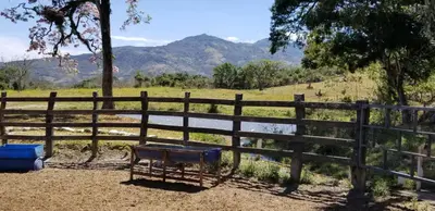 a fence with a bench next to a pond at Hotel Hacienda El Rodeo in Rodeo